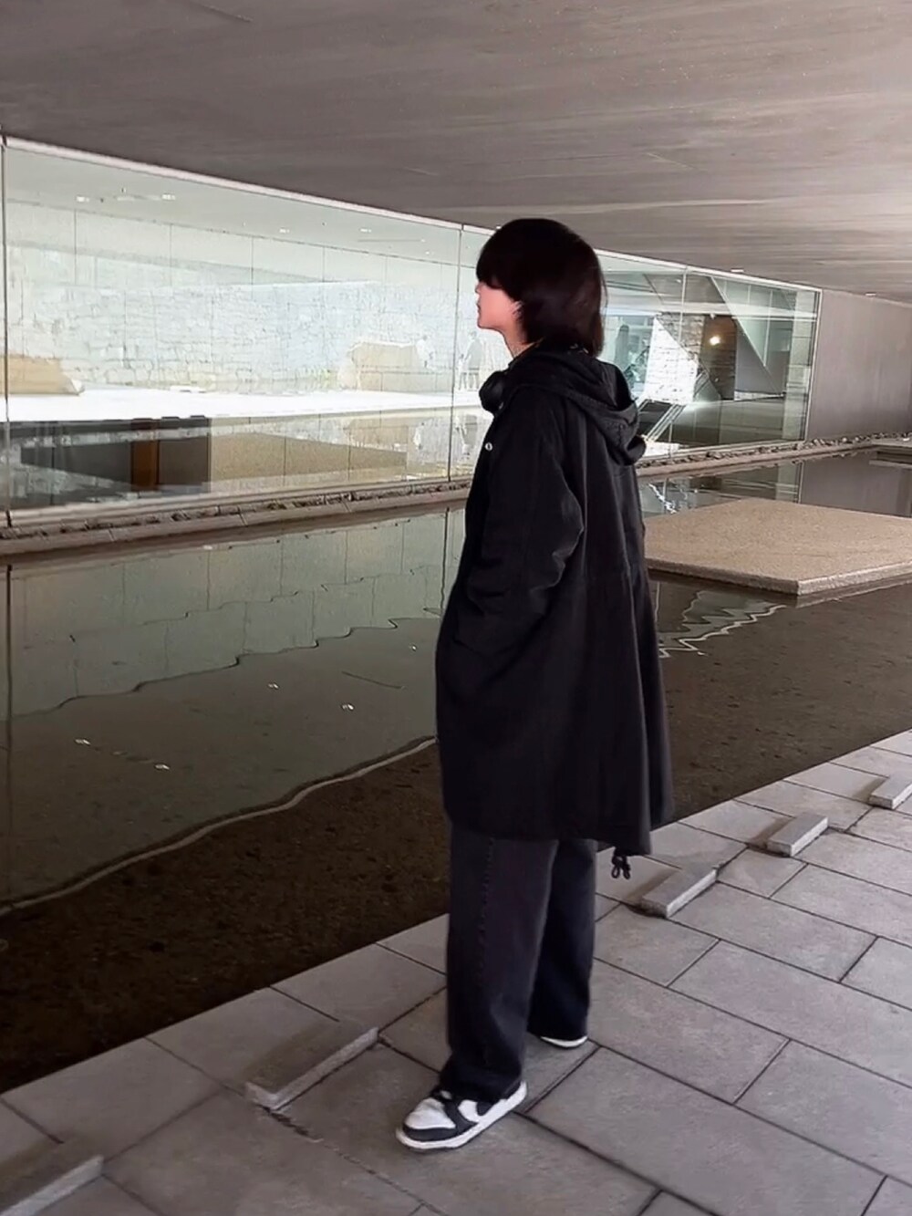 ブラック系のニット/セーター、ブラック系のモッズコート、ブラック系のスニーカーを着用したメンズの冬コーディネートの2枚目の写真