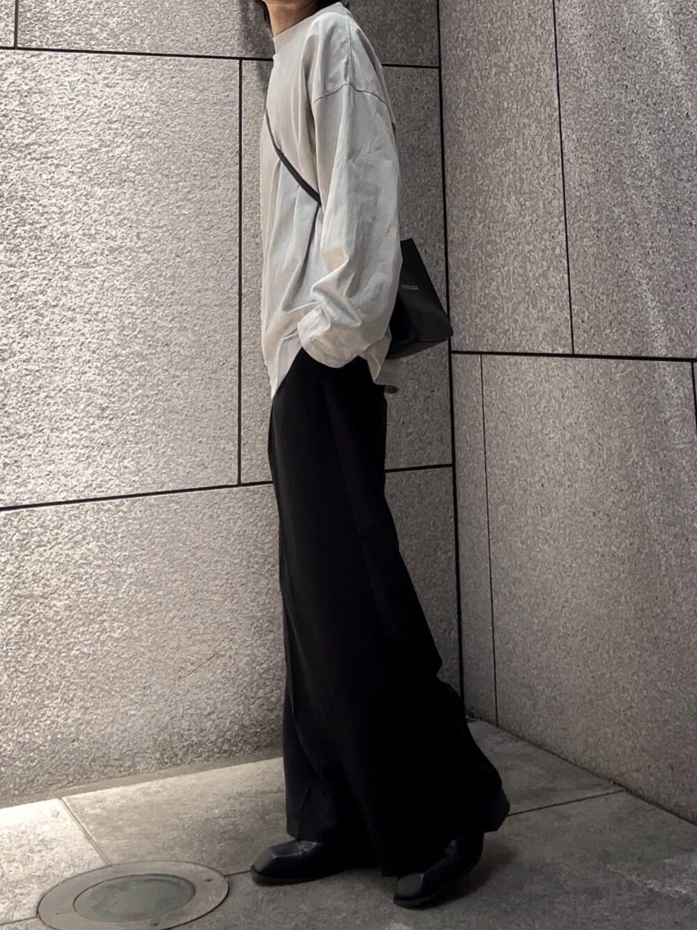 グレー系のTシャツ/カットソー、ブラック系のスラックス、ブラック系のブーツを着用したメンズの夏コーディネートの2枚目の写真