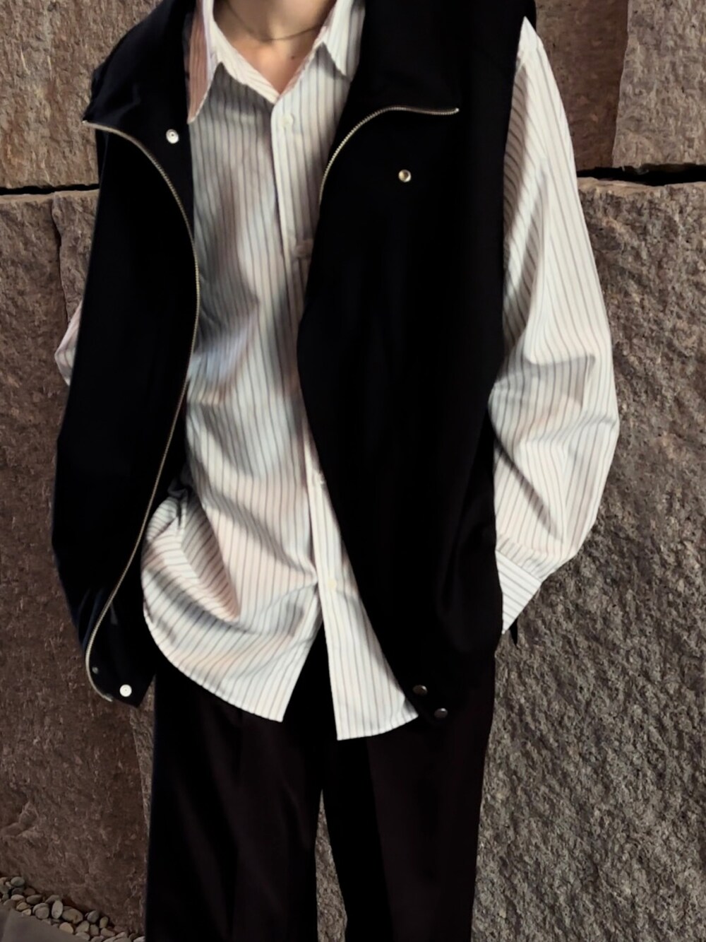 ブラック系のベスト、グレー系のシャツ/ブラウス、ブラック系のスラックスを着用したメンズの春コーディネートの3枚目の写真