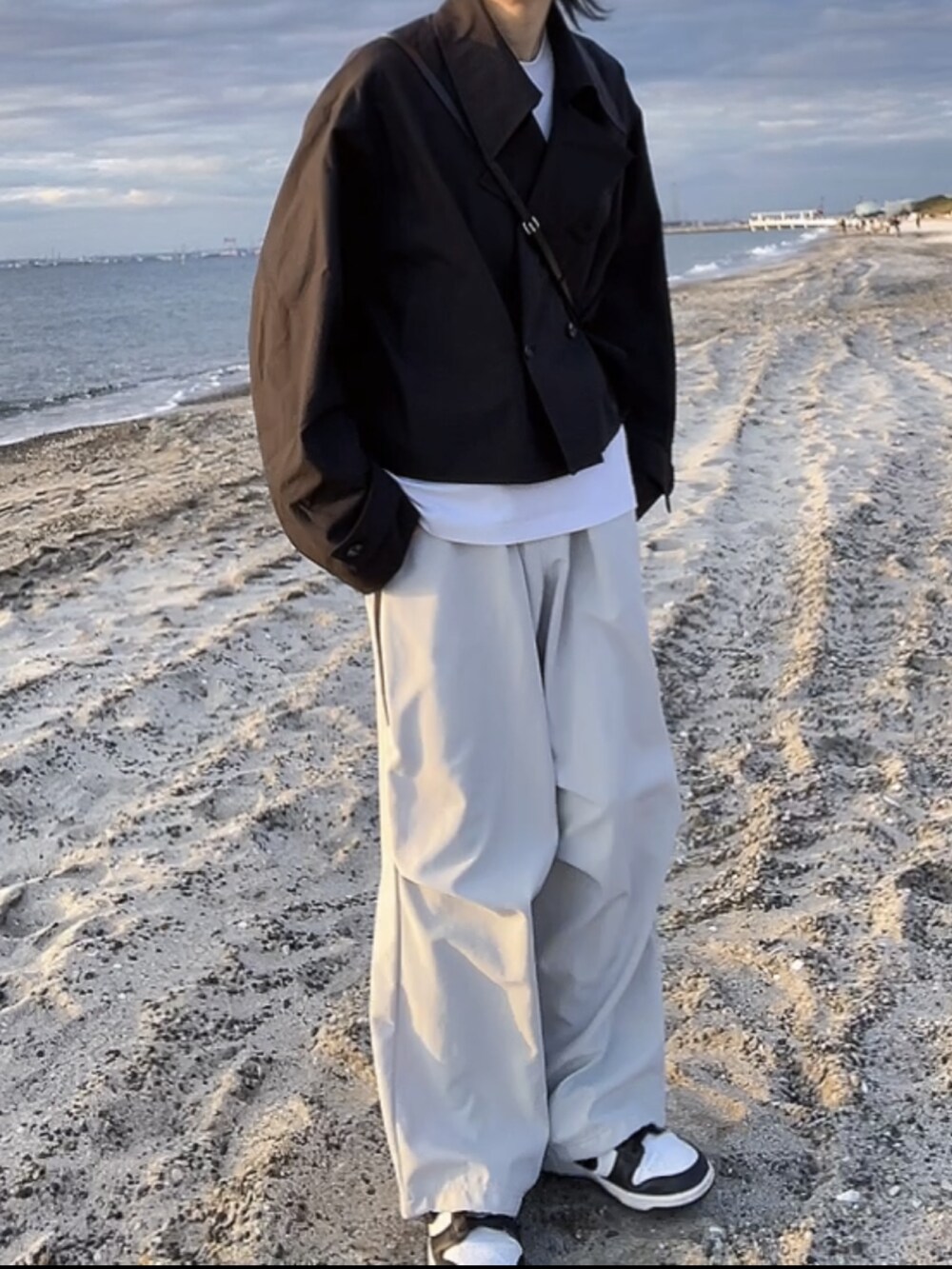 ブラック系のテーラードジャケット、グレー系のその他パンツ、ブラック系のスニーカーを着用したメンズの冬コーディネートの2枚目の写真