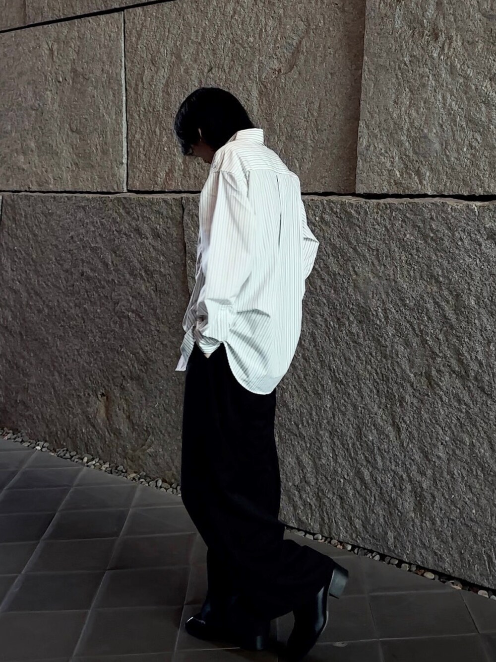 グレー系のシャツ/ブラウス、ブラック系のスラックス、ブラック系のブーツを着用したメンズの春コーディネートの2枚目の写真