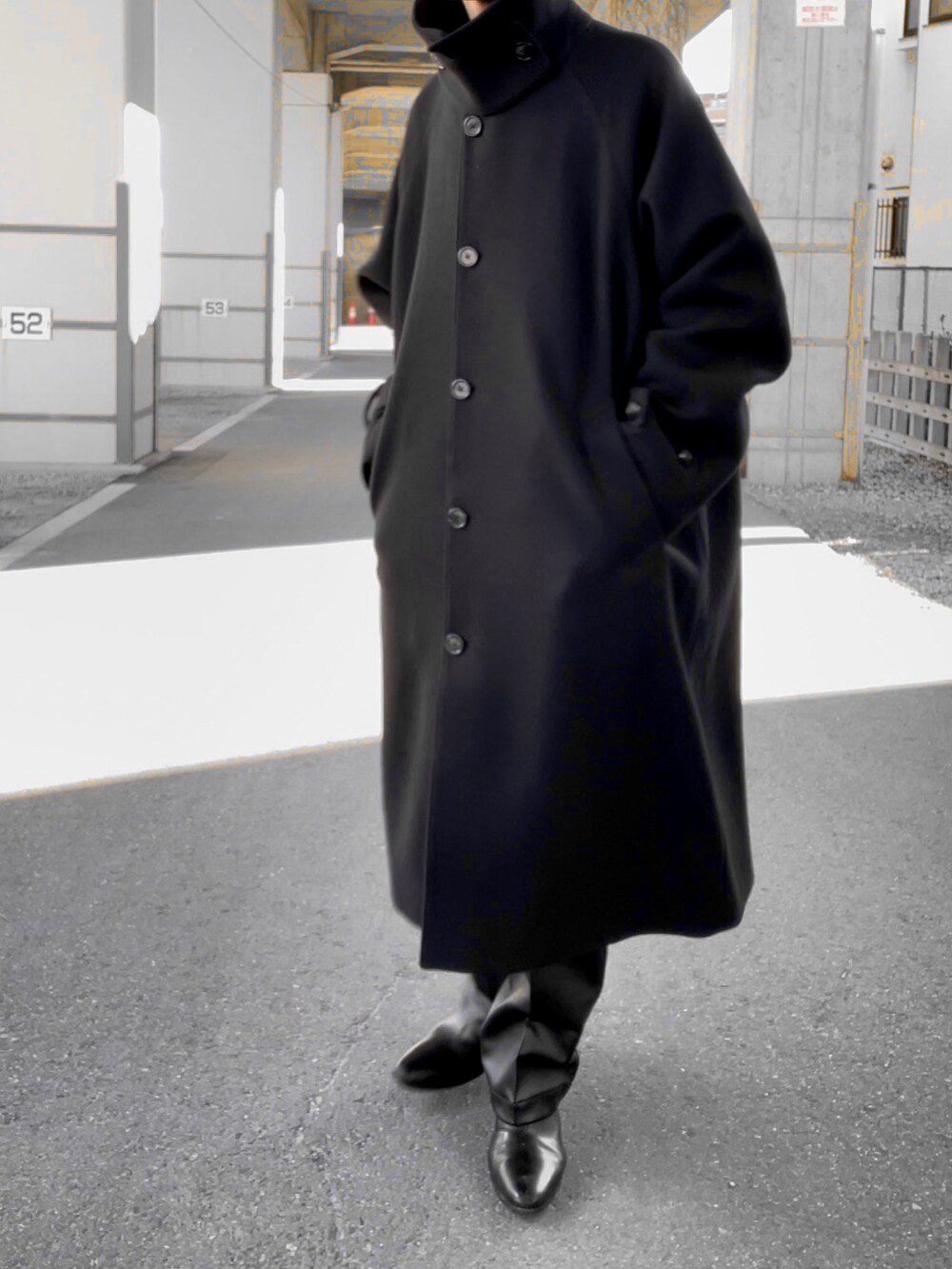 ブラック系のその他パンツ、ブラック系のブーツ、ブラック系のステンカラーコートを着用したメンズの冬コーディネートの2枚目の写真