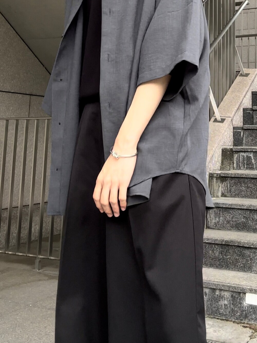 グレー系のシャツ/ブラウス、ブラック系のスラックス、ブラック系のブーツを着用したメンズの夏コーディネートの3枚目の写真