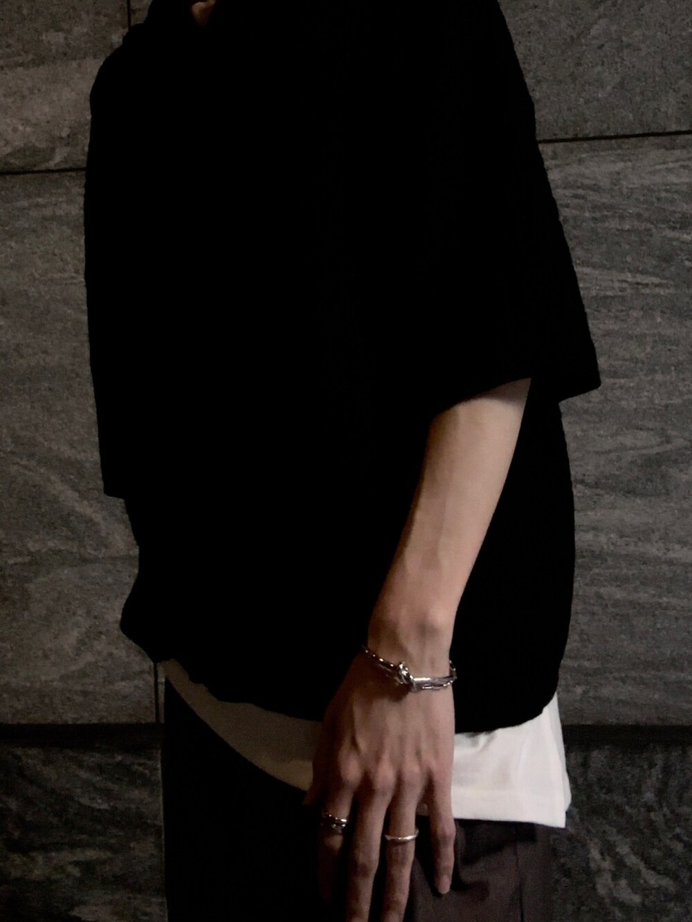 ブラック系のポロシャツ、ベージュ系のその他パンツ、ブラック系のブーツを着用したメンズの春コーディネートの4枚目の写真