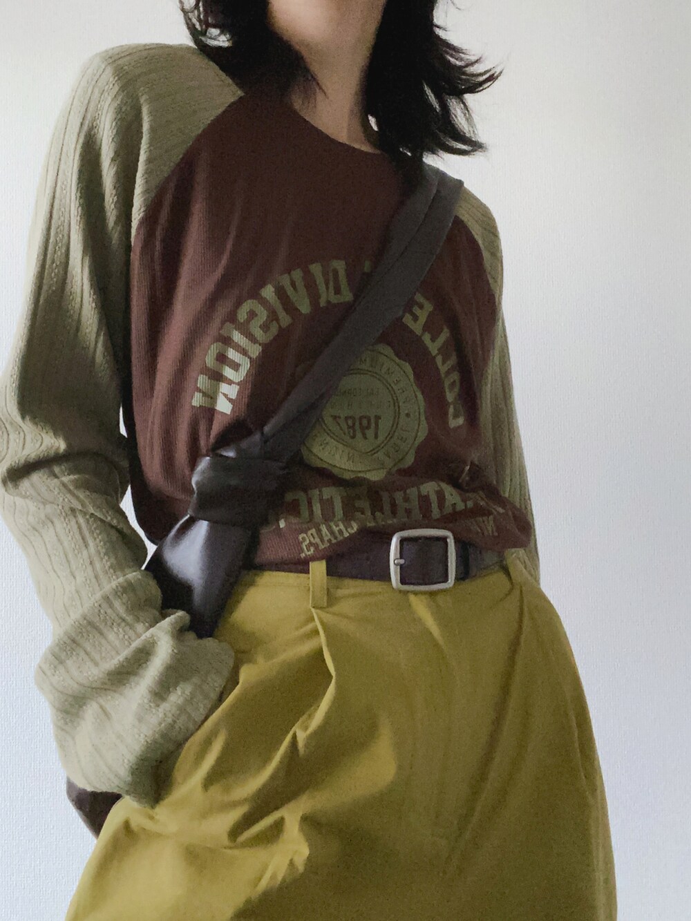 グリーン系のニット/セーターを着用したレディースの冬コーディネートの2枚目の写真