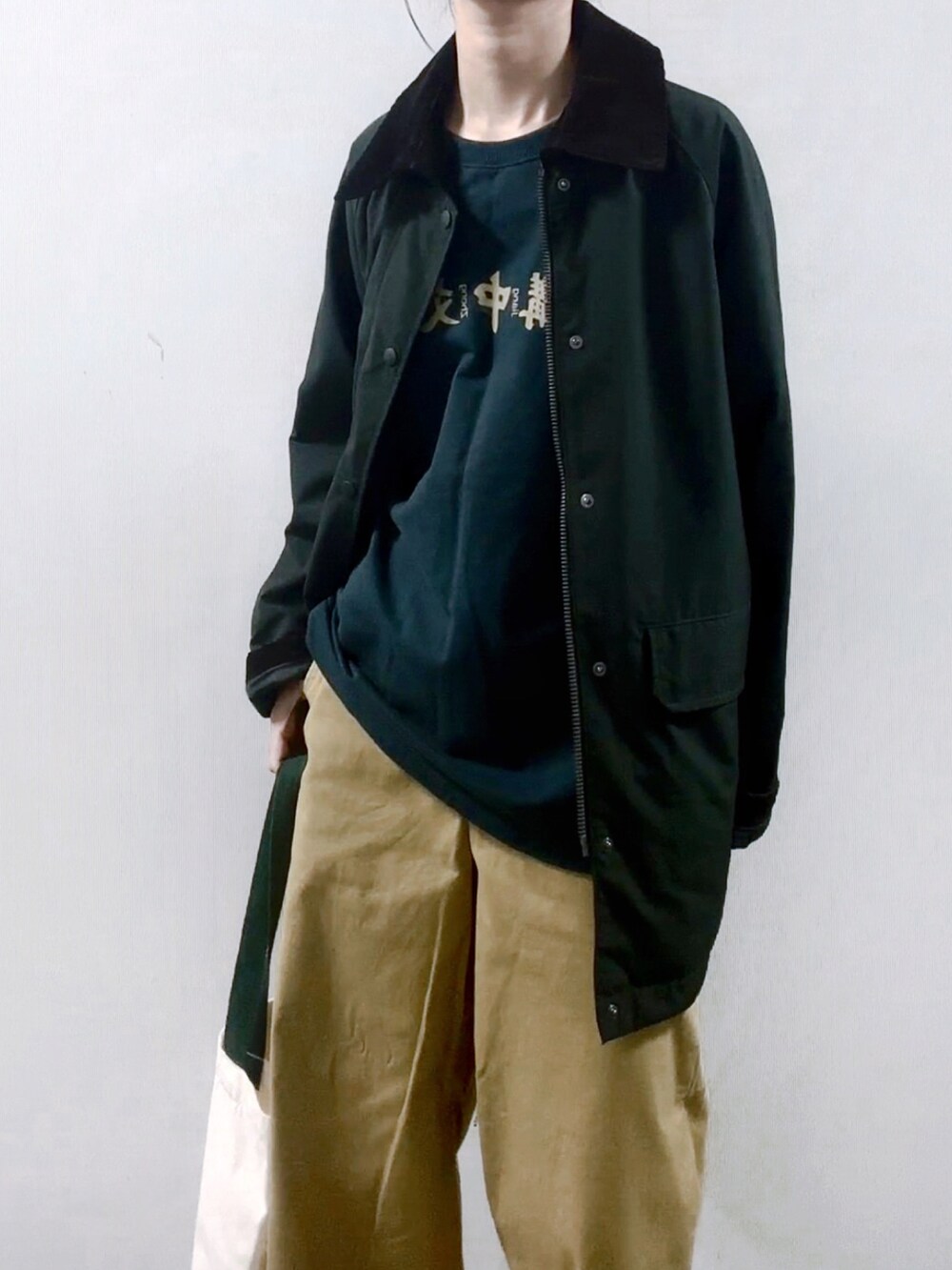 グリーン系のTシャツ/カットソーを着用したレディースの秋コーディネートの2枚目の写真