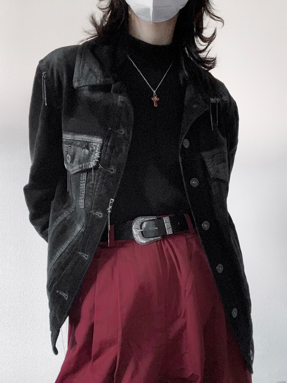 レッド系のチノパンツ、ブラック系のブルゾン、ブラック系のその他トップスを着用したレディースの冬コーディネートの2枚目の写真