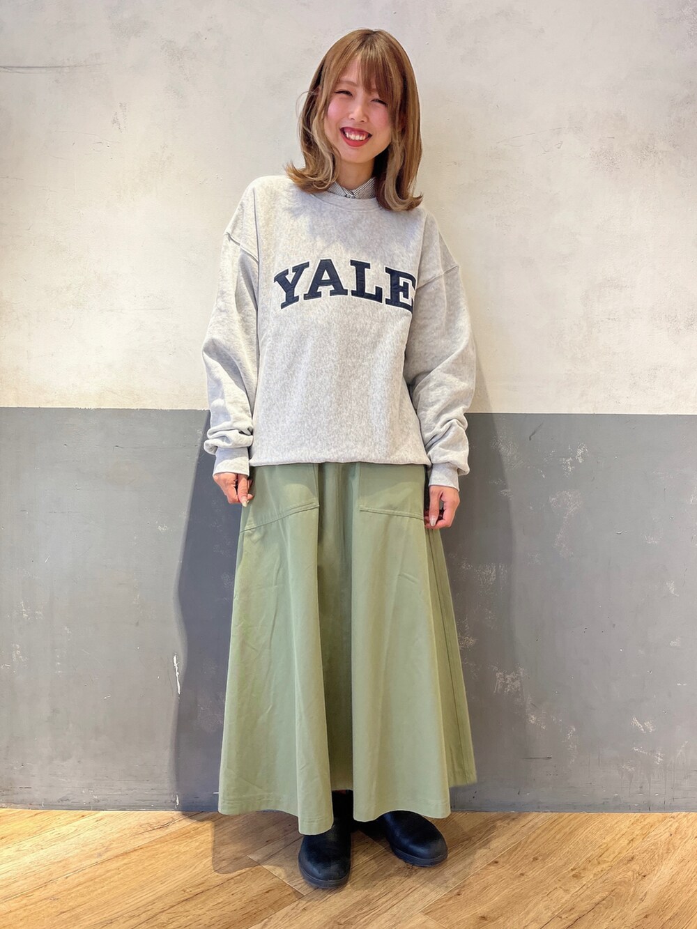 グレー系のスウェット、ブルー系のシャツ/ブラウス、グリーン系のスカートを着用したレディースの冬コーディネートの2枚目の写真