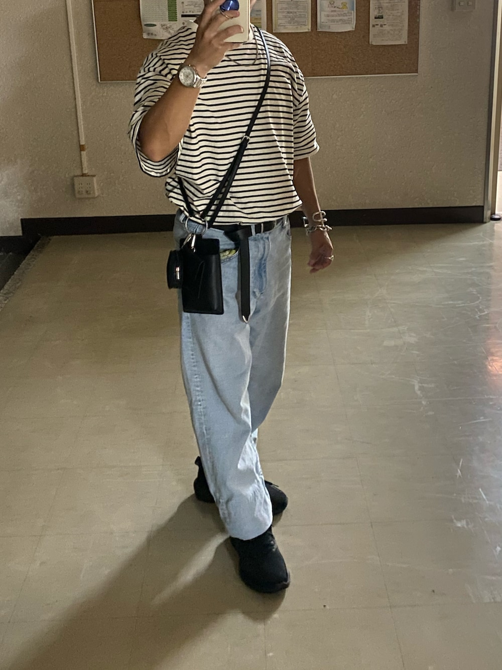 ブルー系のデニムパンツ、ブラック系のスニーカー、ホワイト系のTシャツ/カットソーを着用したメンズの秋コーディネートの2枚目の写真