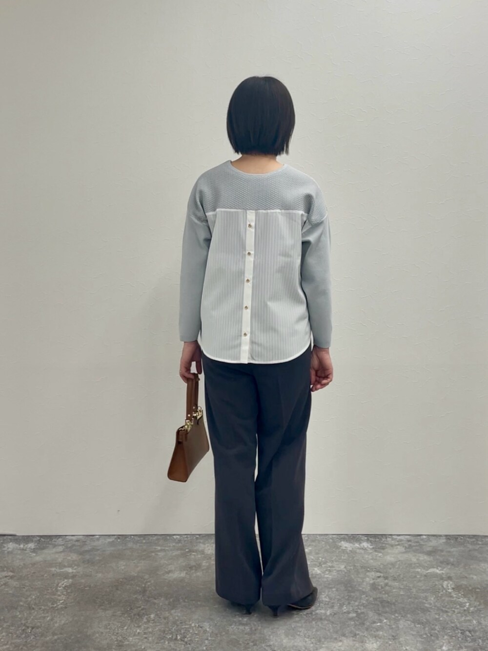 グレー系のその他パンツ、グレー系のニット/セーターを着用したレディースの冬コーディネートの3枚目の写真