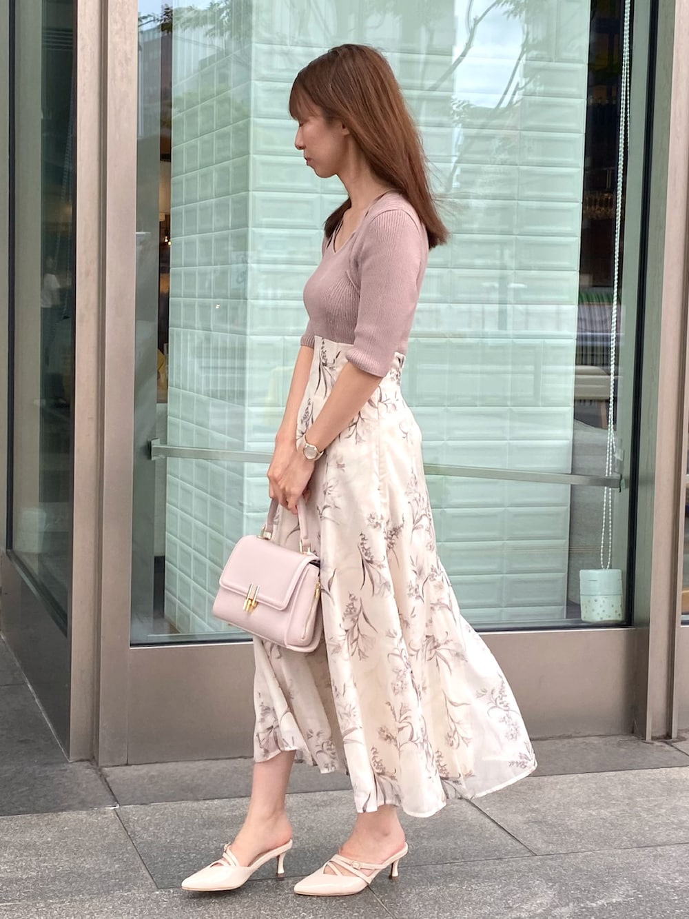 ベージュ系のワンピース、ピンク系のハンドバッグ、ベージュ系のパンプスを着用したレディースの夏コーディネートの2枚目の写真