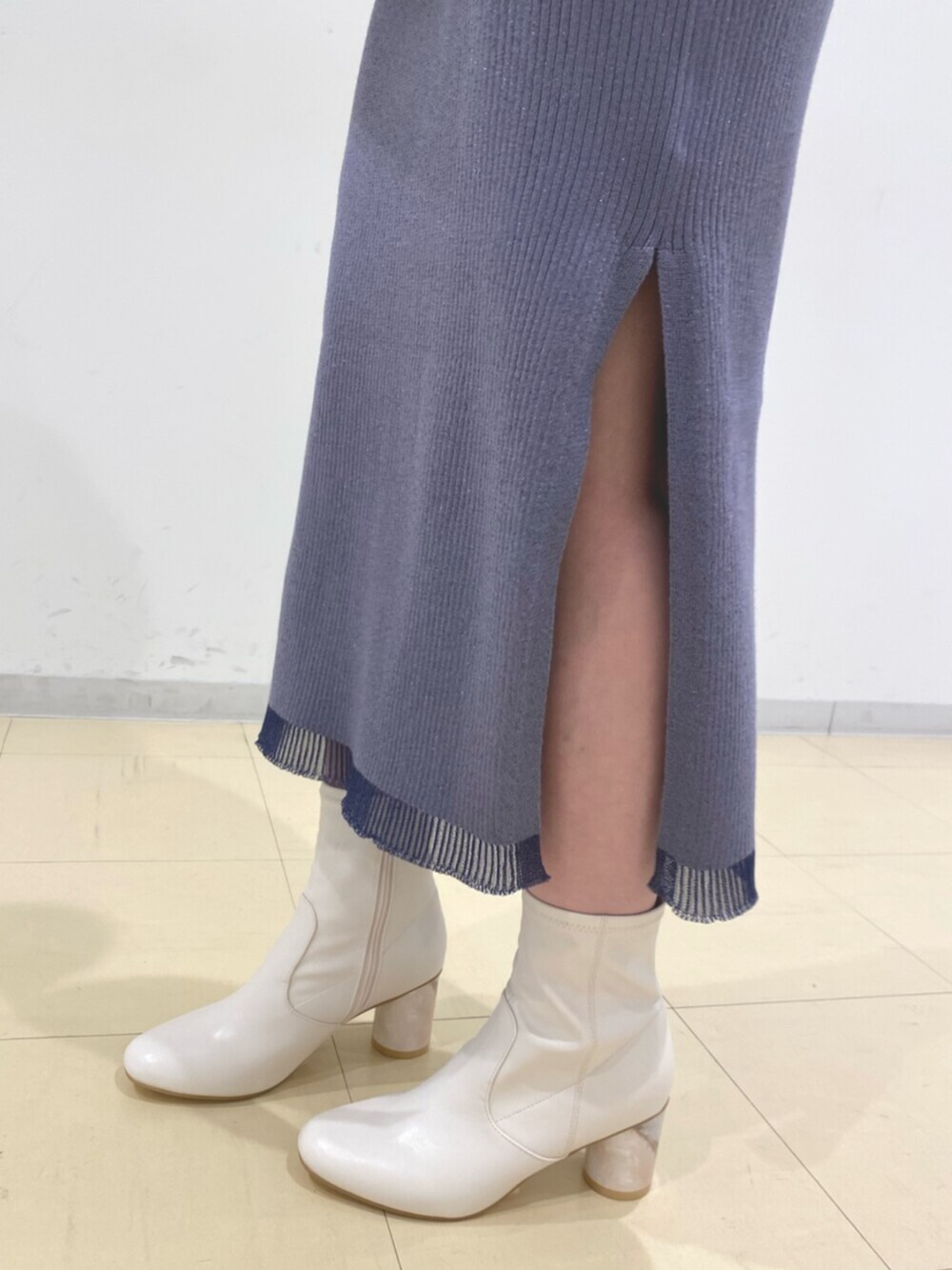 ホワイト系のブーツ、ブルー系のワンピース、ブラック系のハンドバッグを着用したレディースの冬コーディネートの6枚目の写真