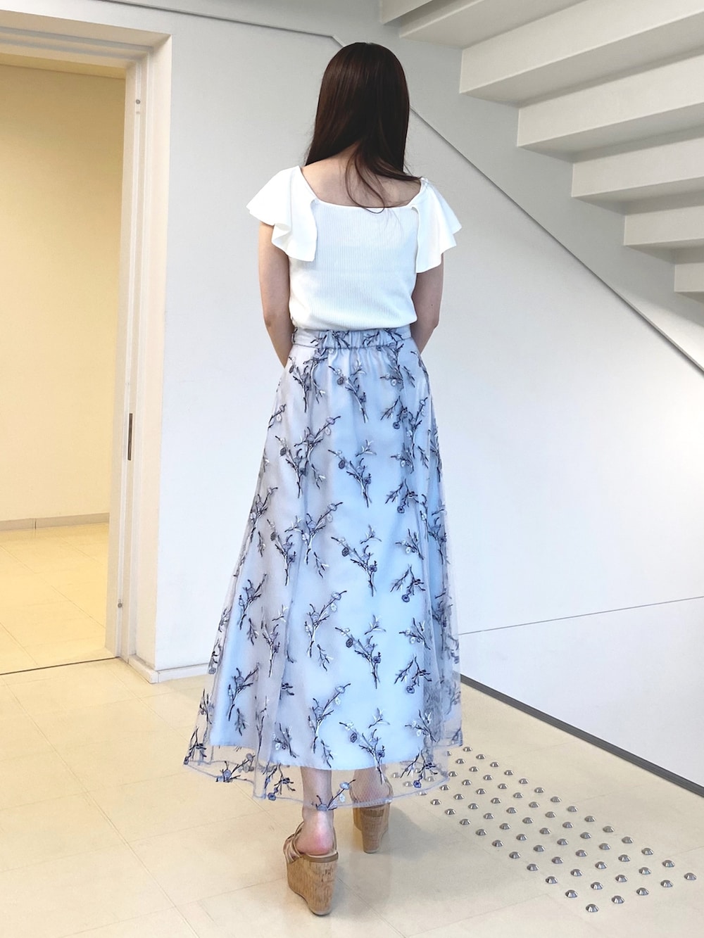 ホワイト系のニット/セーター、ブルー系のスカート、ホワイト系のハンドバッグを着用したレディースの春コーディネートの3枚目の写真