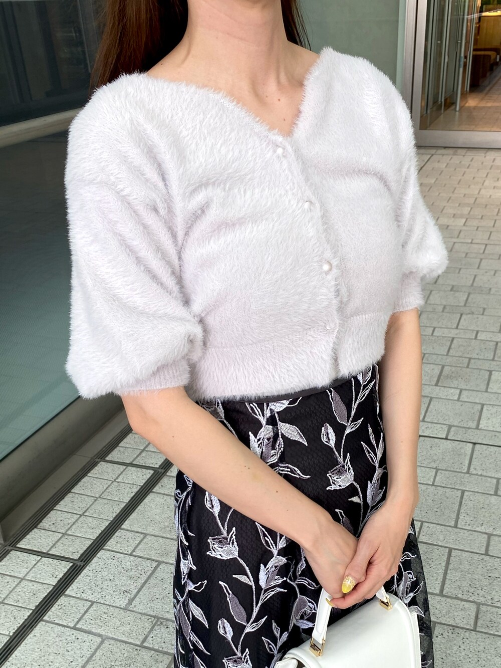 パープル系のカーディガン/ボレロ、グレー系のスカート、ホワイト系のハンドバッグを着用したレディースの夏コーディネートの6枚目の写真