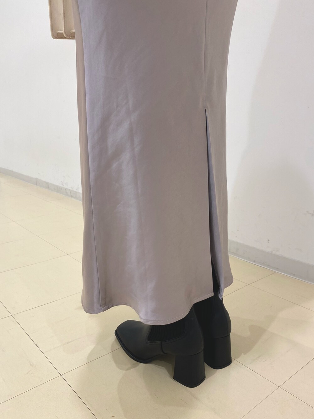 ホワイト系のカーディガン/ボレロ、パープル系のスカート、ブラック系のブーツを着用したレディースの秋コーディネートの5枚目の写真