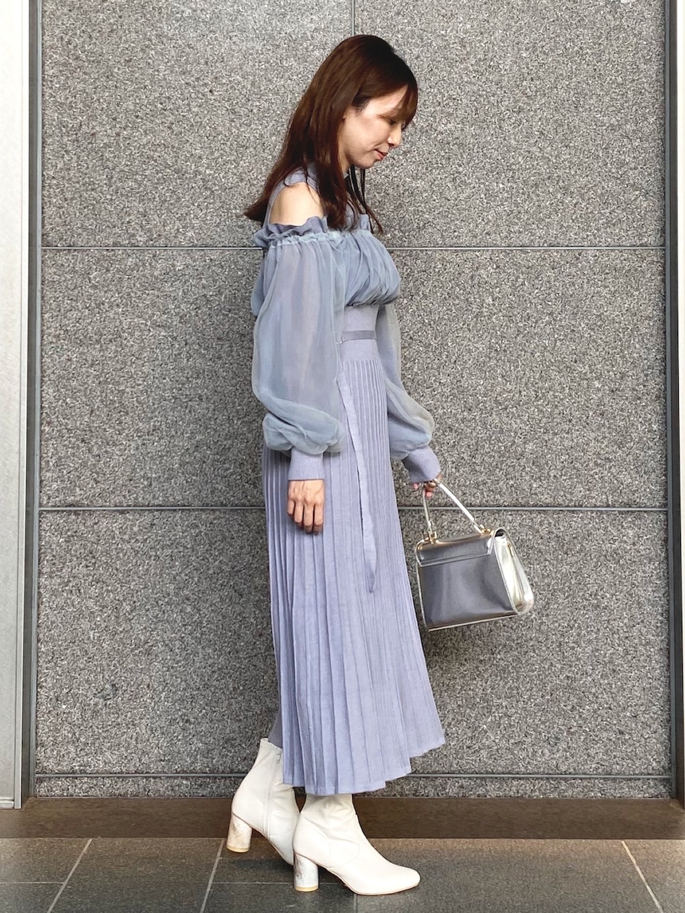 ブルー系のワンピース、シルバー系のハンドバッグ、ホワイト系のブーツを着用したレディースの秋コーディネートの4枚目の写真