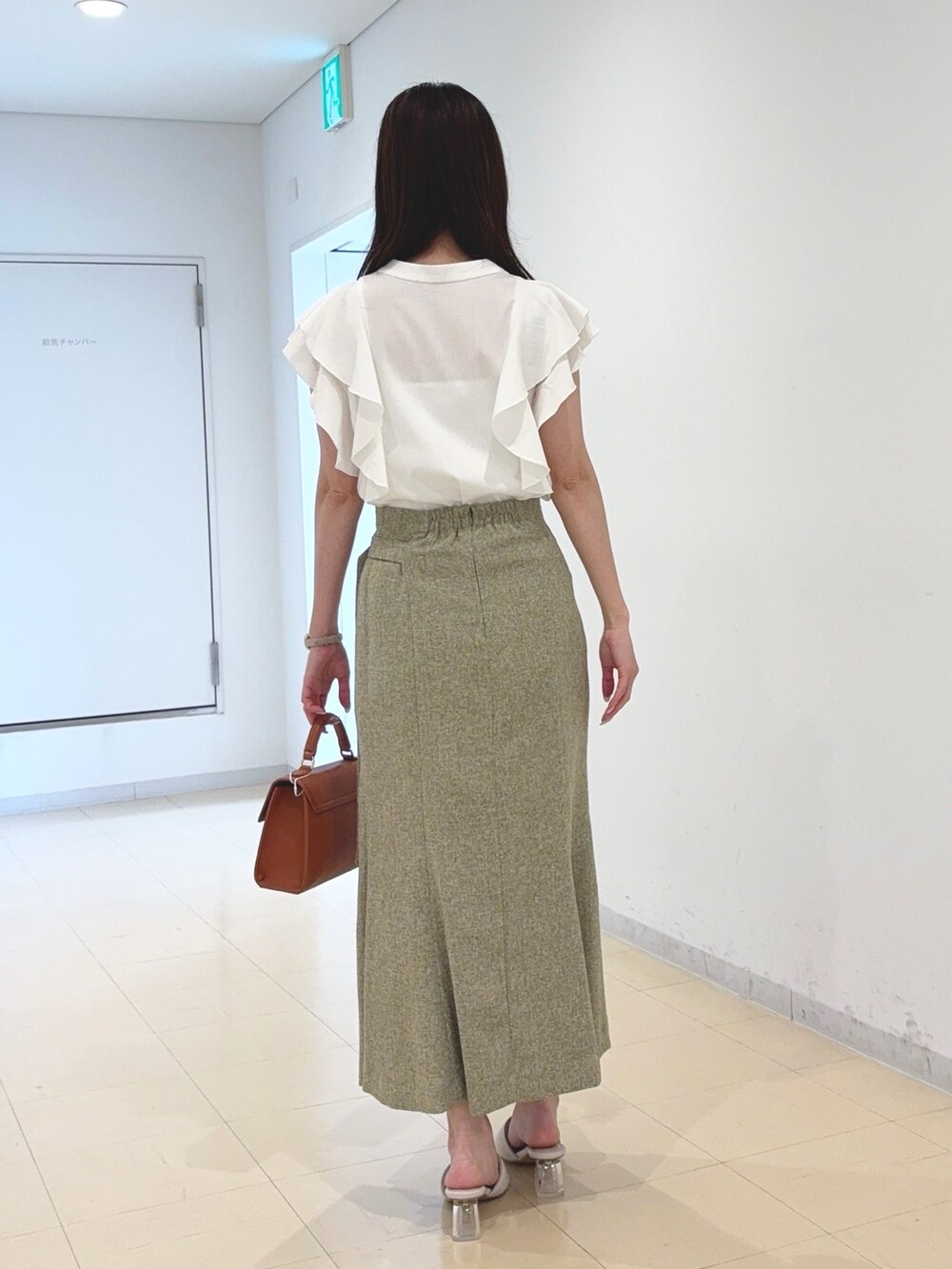 ホワイト系のシャツ/ブラウス、グリーン系のスカート、ブラウン系のハンドバッグを着用したレディースの春コーディネートの3枚目の写真