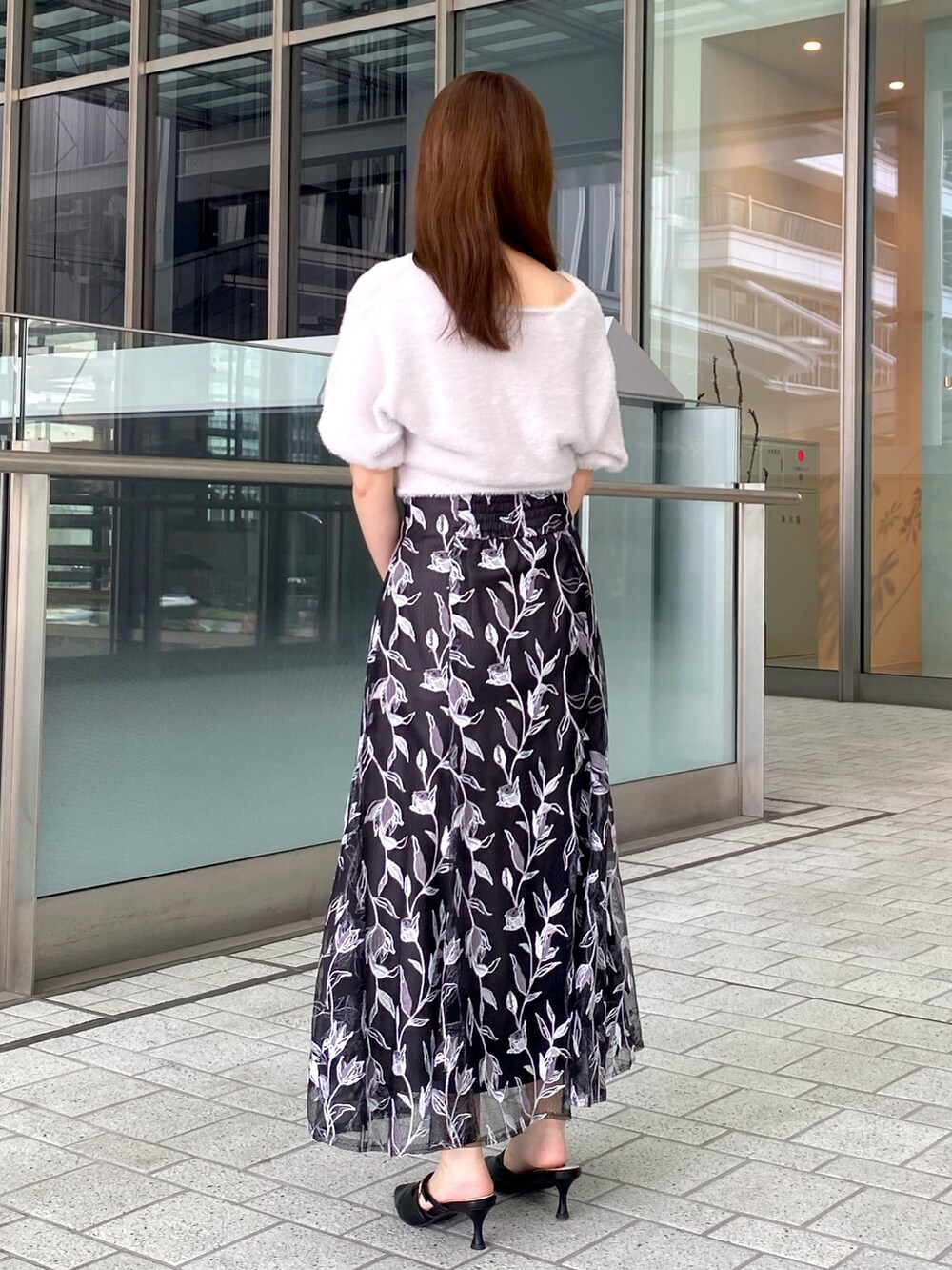 パープル系のカーディガン/ボレロ、グレー系のスカート、ホワイト系のハンドバッグを着用したレディースの夏コーディネートの3枚目の写真