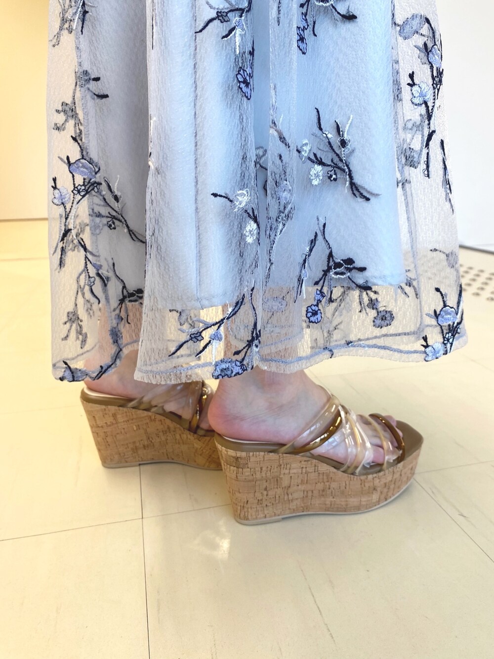 ホワイト系のニット/セーター、ブルー系のスカート、ホワイト系のハンドバッグを着用したレディースの春コーディネートの6枚目の写真