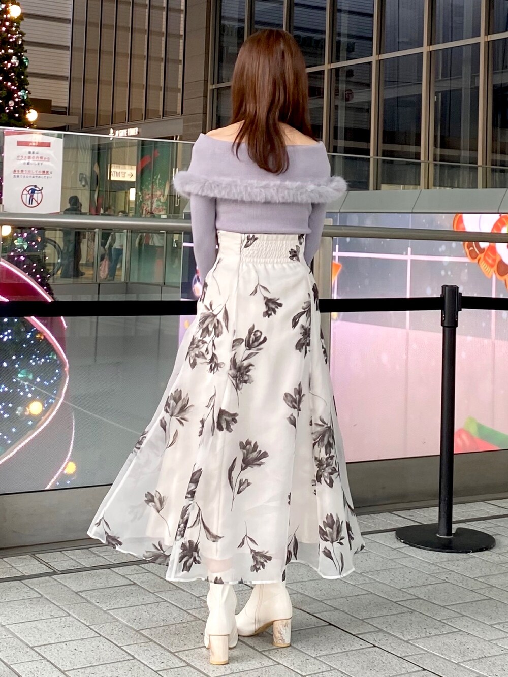 グレー系のニット/セーター、ホワイト系のスカート、シルバー系のハンドバッグを着用したレディースの冬コーディネートの3枚目の写真