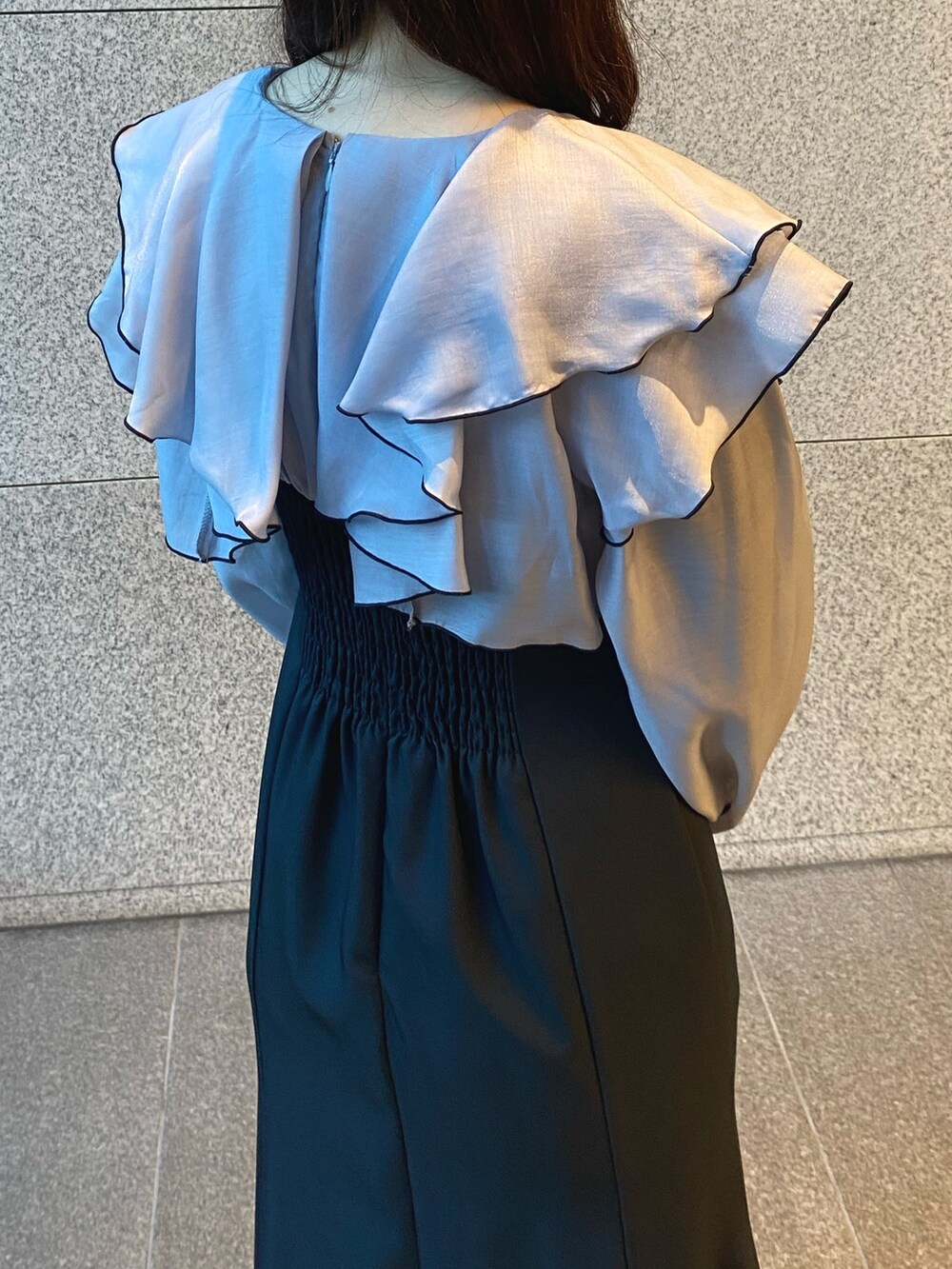 ブラック系のショルダーバッグ、グレー系のワンピース、ゴールド系のブーツを着用したレディースの冬コーディネートの6枚目の写真