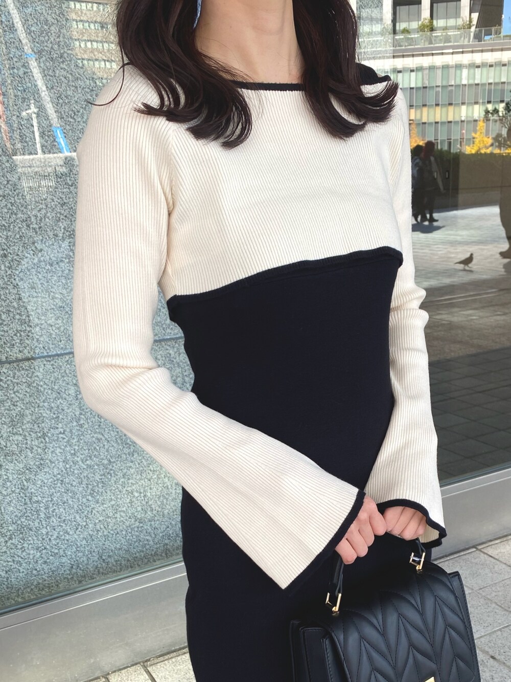 ブラック系のワンピース、ブラック系のショルダーバッグ、ブラウン系のブーツを着用したレディースの冬コーディネートの5枚目の写真