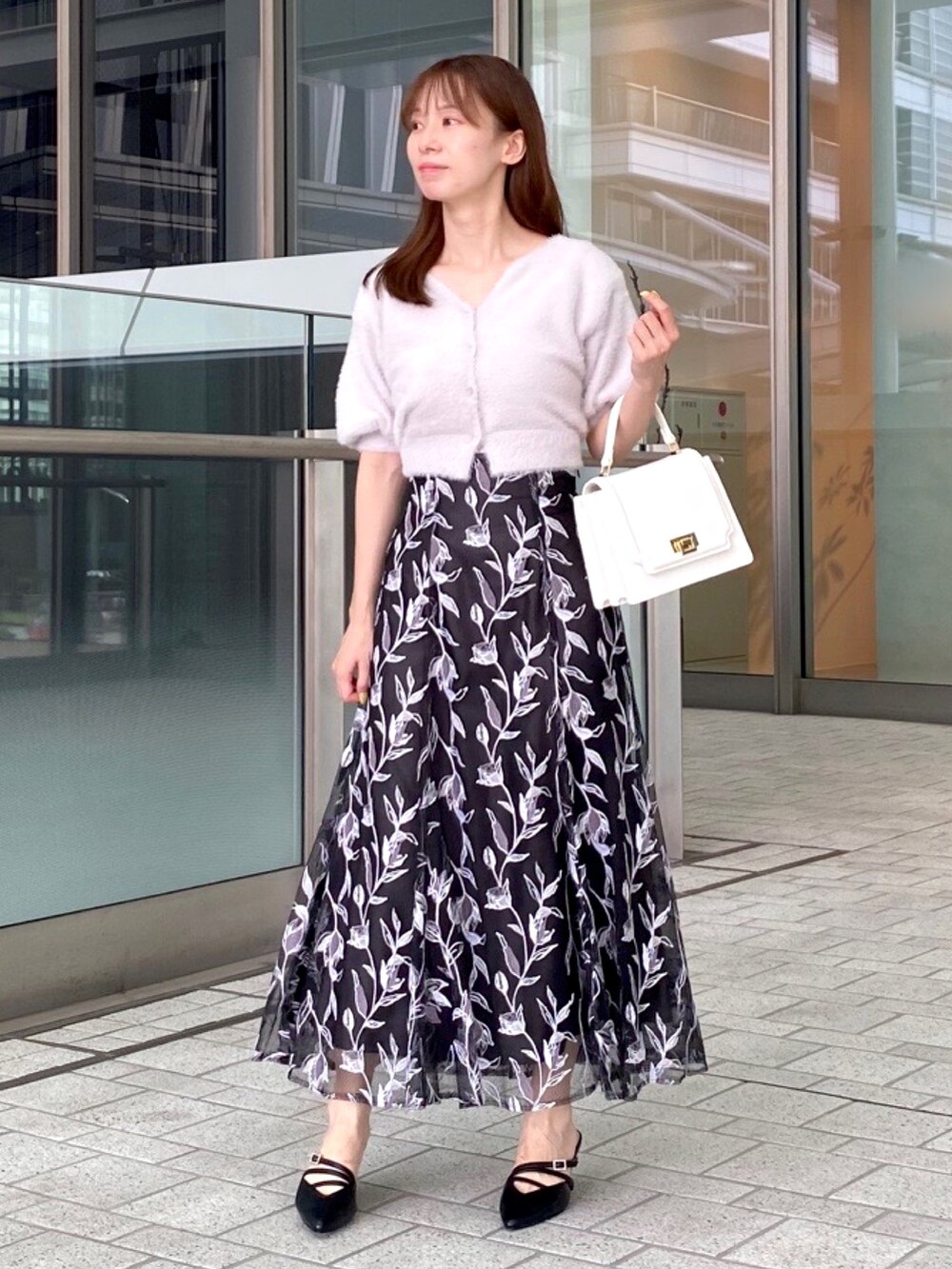 パープル系のカーディガン/ボレロ、グレー系のスカート、ホワイト系のハンドバッグを着用したレディースの夏コーディネートの5枚目の写真