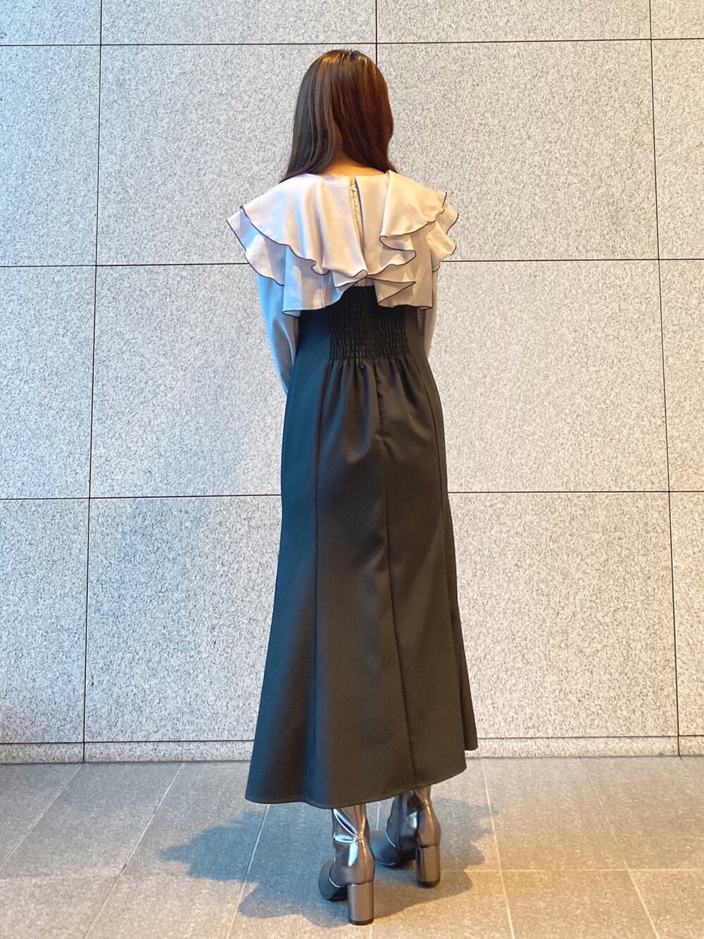 ブラック系のショルダーバッグ、グレー系のワンピース、ゴールド系のブーツを着用したレディースの冬コーディネートの4枚目の写真