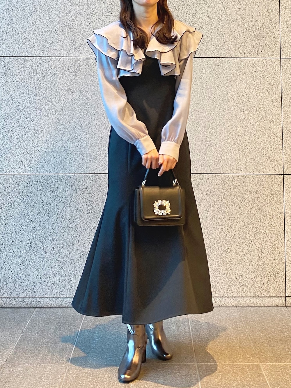 ブラック系のショルダーバッグ、グレー系のワンピース、ゴールド系のブーツを着用したレディースの冬コーディネートの2枚目の写真