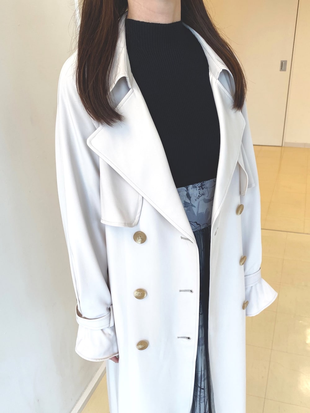 ブラック系のワンピース、ホワイト系のブーツ、ピンク系のトレンチコートを着用したレディースの春コーディネートの6枚目の写真