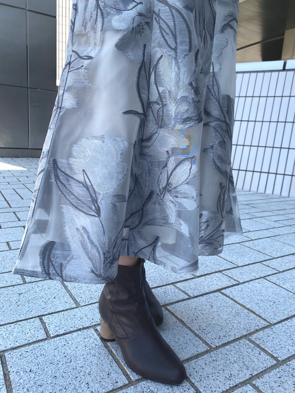 ホワイト系のトレンチコート、グレー系のワンピース、ブラック系のハンドバッグを着用したレディースの春コーディネートの7枚目の写真