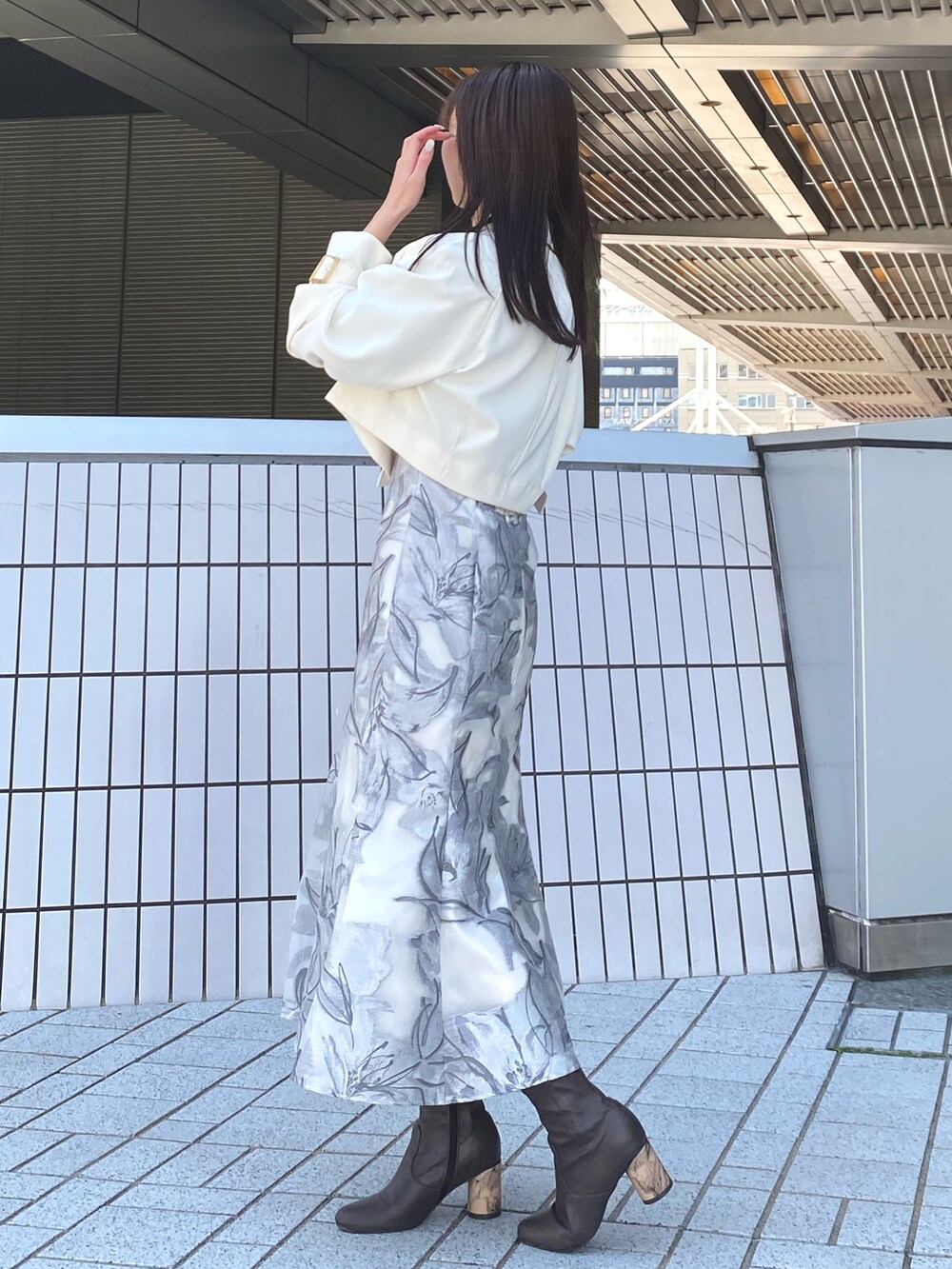 ホワイト系のトレンチコート、グレー系のワンピース、ブラック系のハンドバッグを着用したレディースの春コーディネートの3枚目の写真