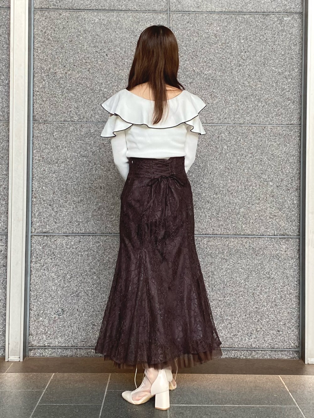 ホワイト系のニット/セーター、ブラウン系のスカート、ブラック系のハンドバッグを着用したレディースの秋コーディネートの4枚目の写真