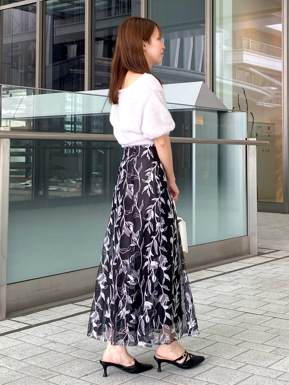 パープル系のカーディガン/ボレロ、グレー系のスカート、ホワイト系のハンドバッグを着用したレディースの夏コーディネートの4枚目の写真