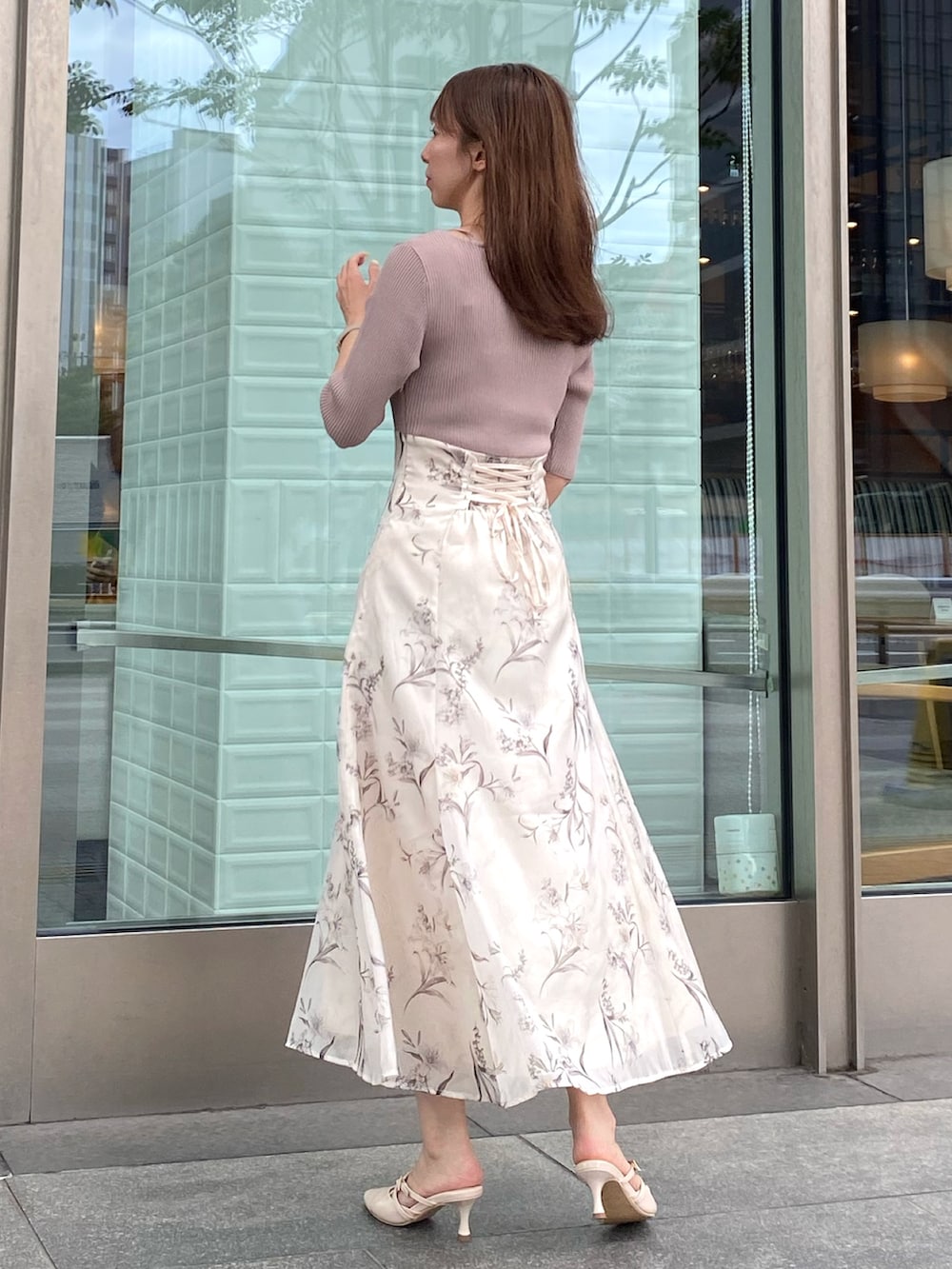 ベージュ系のワンピース、ピンク系のハンドバッグ、ベージュ系のパンプスを着用したレディースの夏コーディネートの3枚目の写真