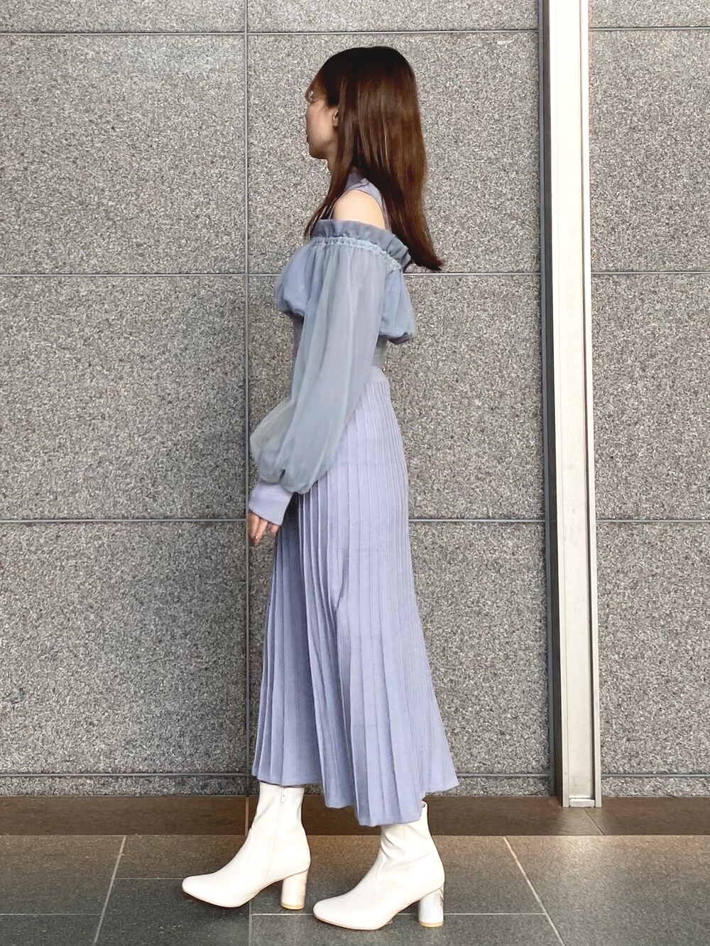 ブルー系のワンピース、シルバー系のハンドバッグ、ホワイト系のブーツを着用したレディースの秋コーディネートの2枚目の写真