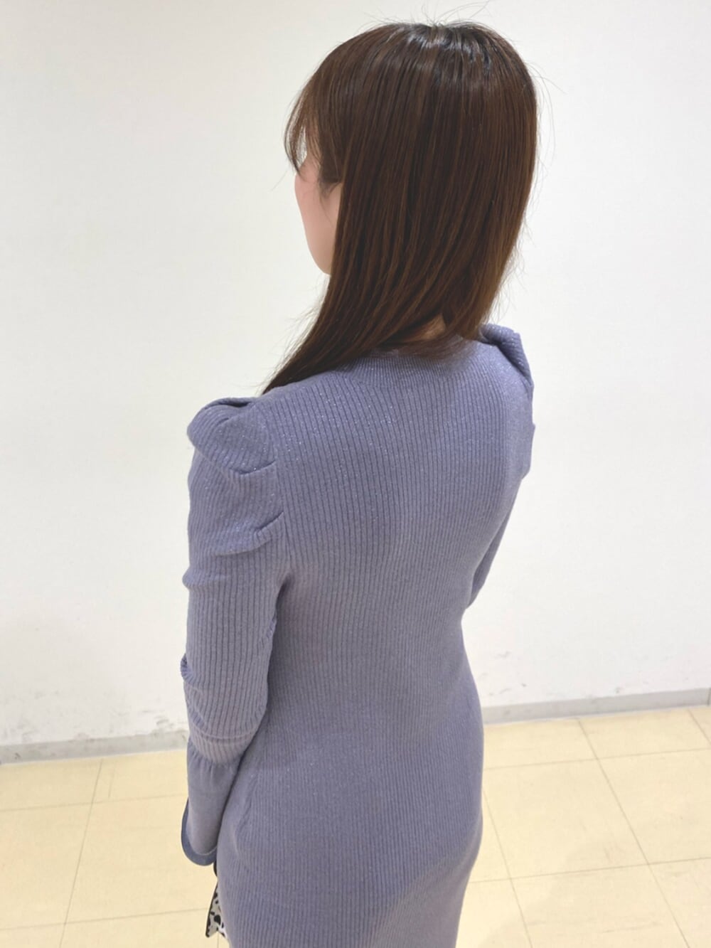 ホワイト系のブーツ、ブルー系のワンピース、ブラック系のハンドバッグを着用したレディースの冬コーディネートの5枚目の写真