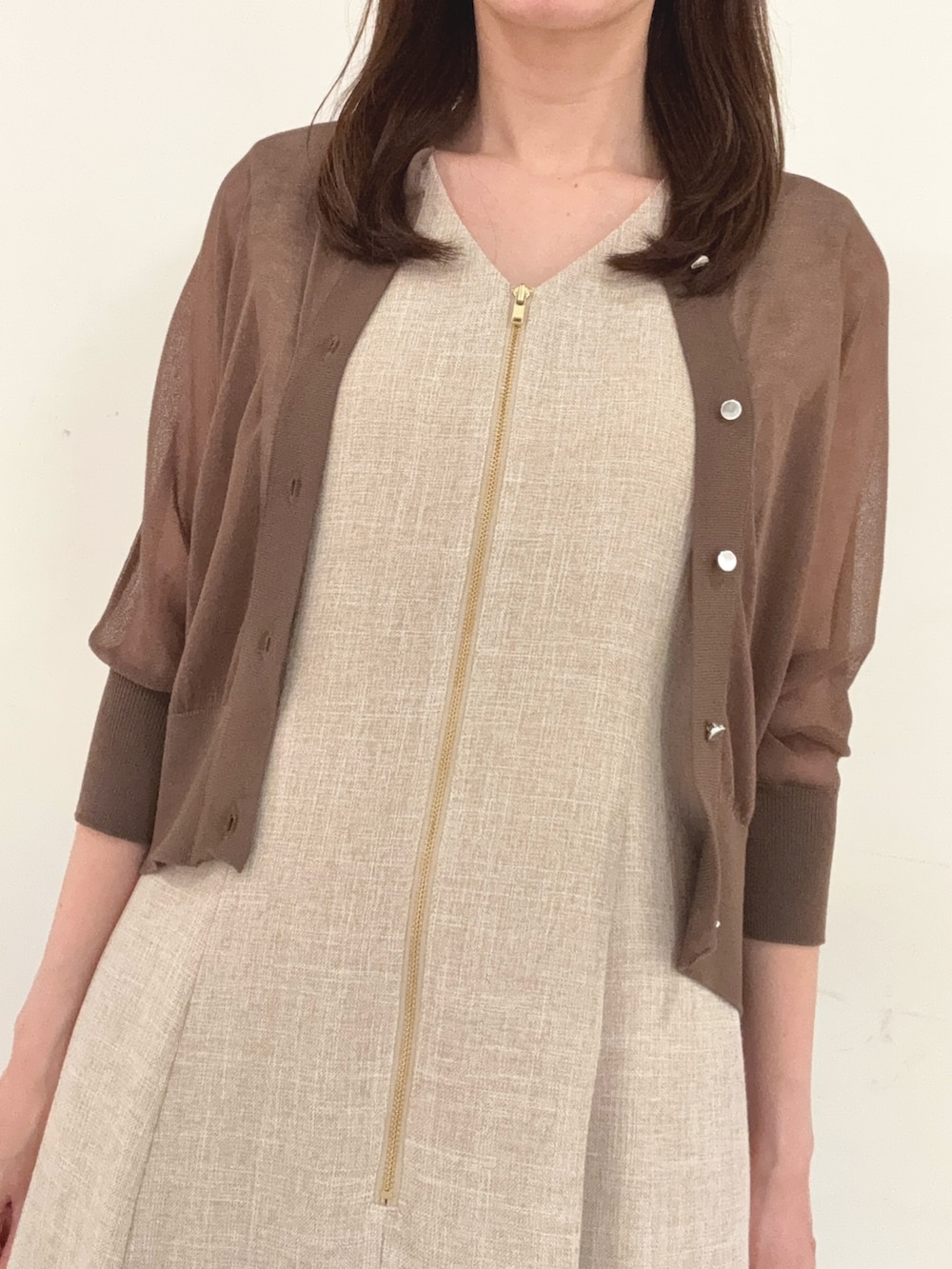 ベージュ系のワンピース、ブラウン系のカーディガン/ボレロ、ブラック系のサンダルを着用したレディースの夏コーディネートの4枚目の写真
