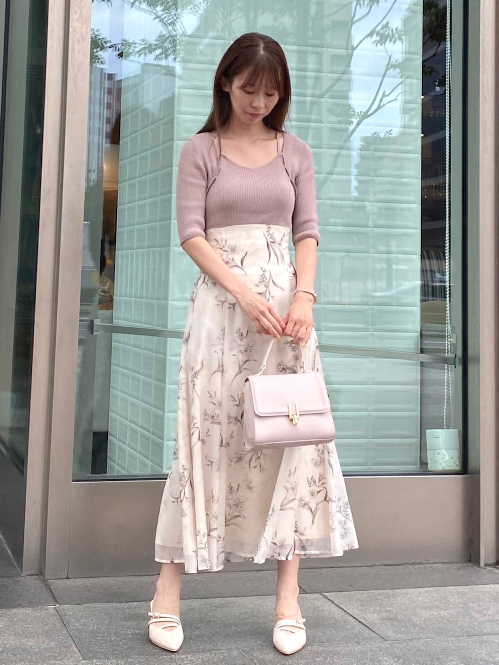 ベージュ系のワンピース、ピンク系のハンドバッグ、ベージュ系のパンプスを着用したレディースの夏コーディネートの4枚目の写真