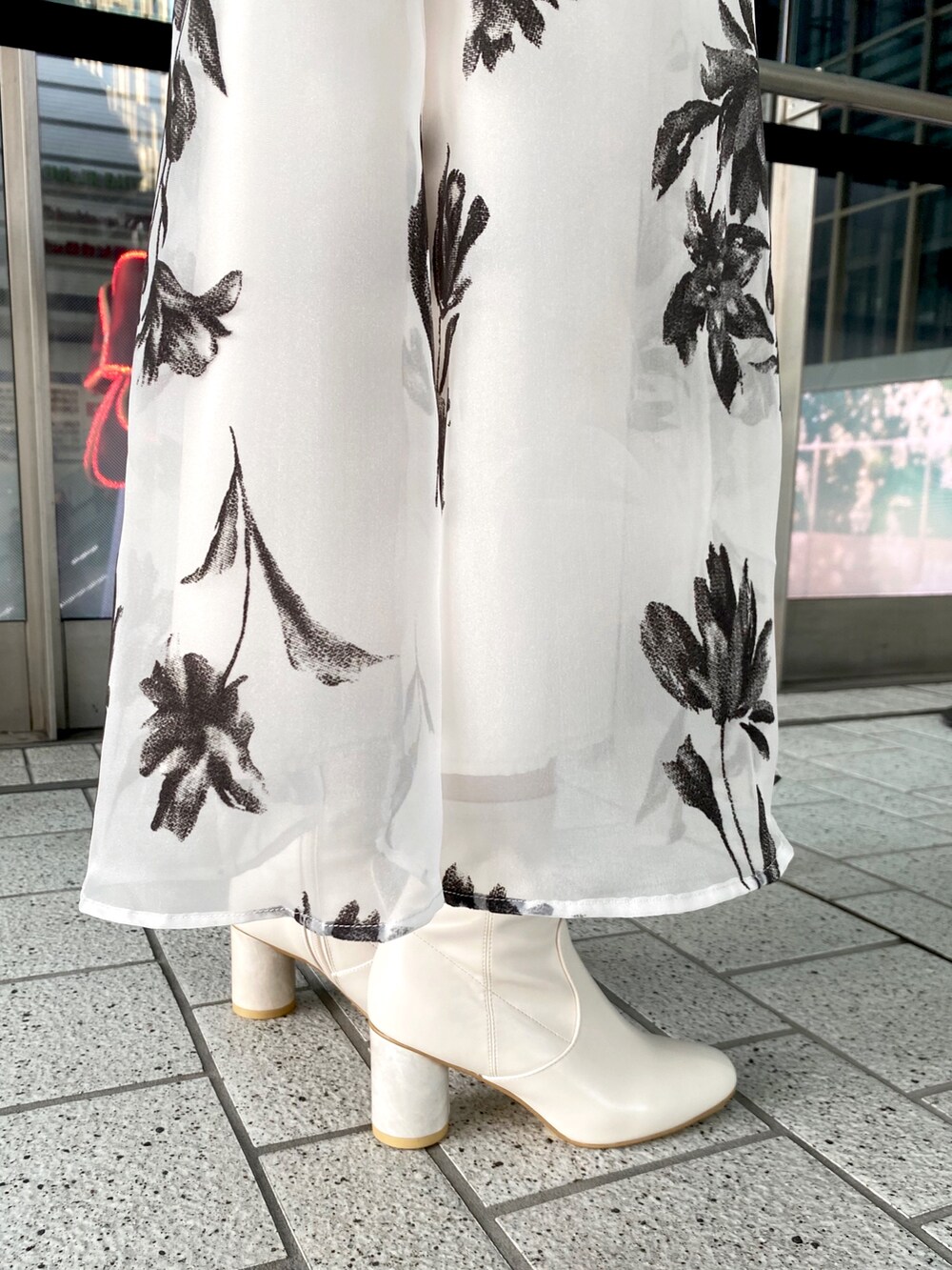 グレー系のニット/セーター、ホワイト系のスカート、シルバー系のハンドバッグを着用したレディースの冬コーディネートの7枚目の写真