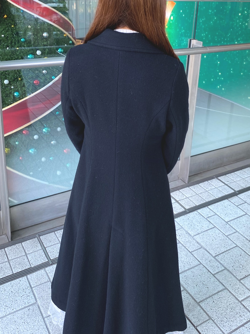 ブラック系のその他アウター、ホワイト系のニット/セーター、ブラック系のブーツを着用したレディースの秋コーディネートの5枚目の写真