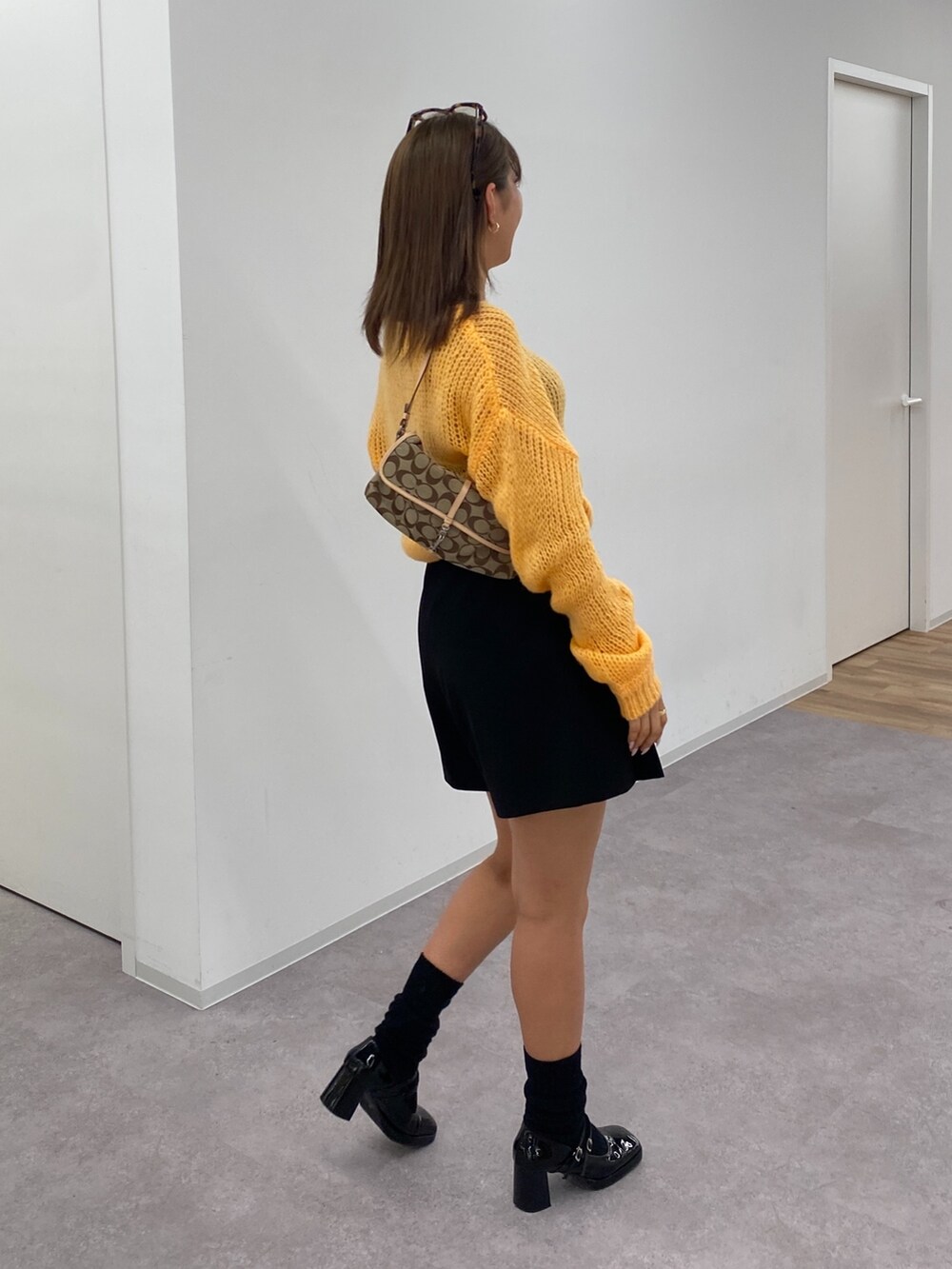 オレンジ系のニット/セーター、ブラック系のその他パンツ、ブラック系のパンプスを着用したレディースの冬コーディネートの2枚目の写真