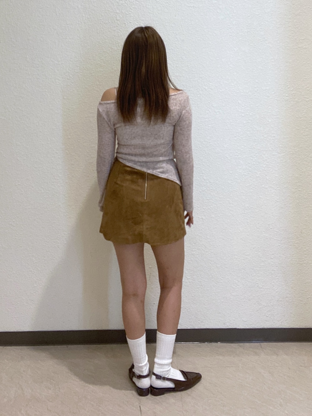 ベージュ系のスカートを着用したレディースの秋コーディネートの2枚目の写真