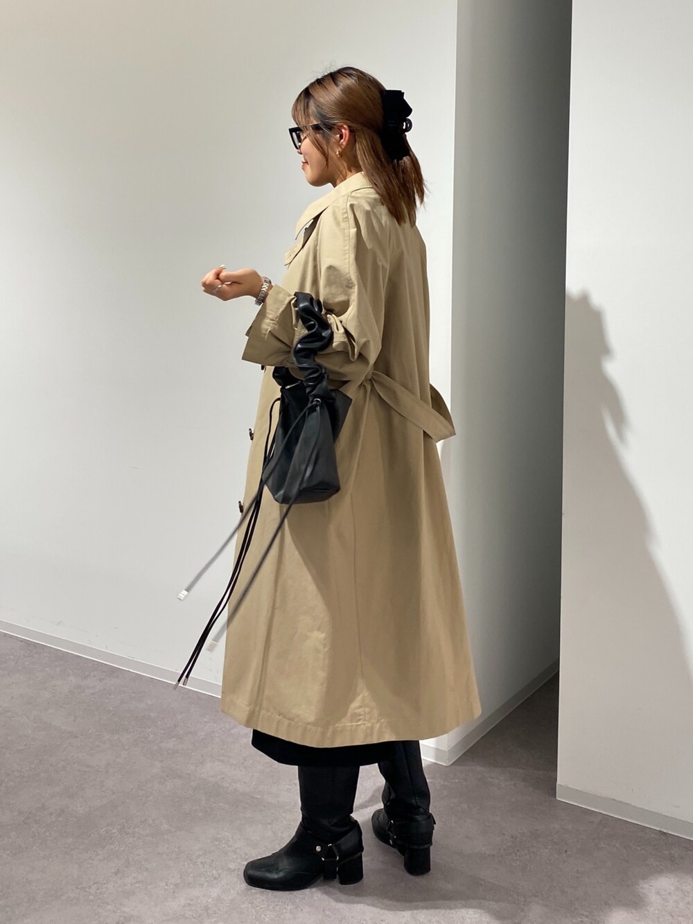 ベージュ系のトレンチコートを着用したレディースの春コーディネートの2枚目の写真