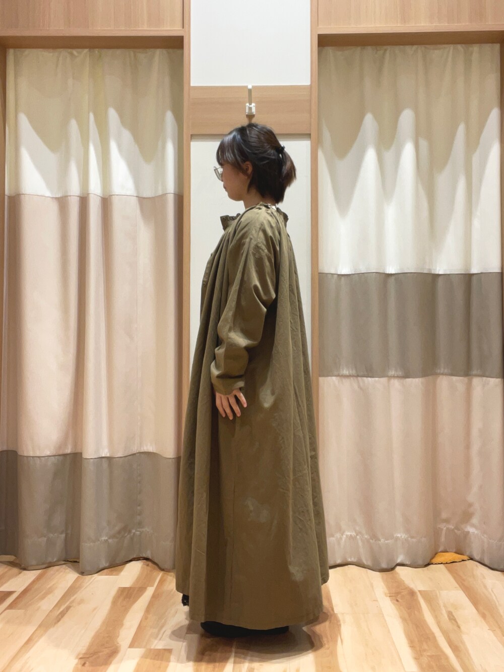 グリーン系のワンピース、ブラック系のスカート、ホワイト系のTシャツ/カットソーを着用したレディースの秋コーディネートの3枚目の写真