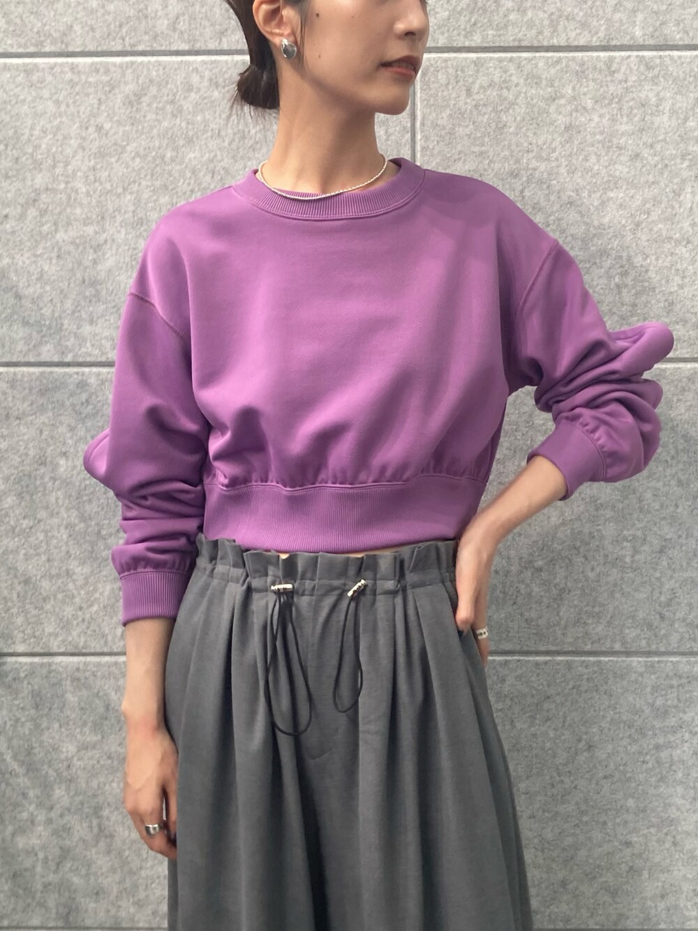 パープル系のスウェット、グレー系のその他パンツを着用したレディースの秋コーディネートの3枚目の写真