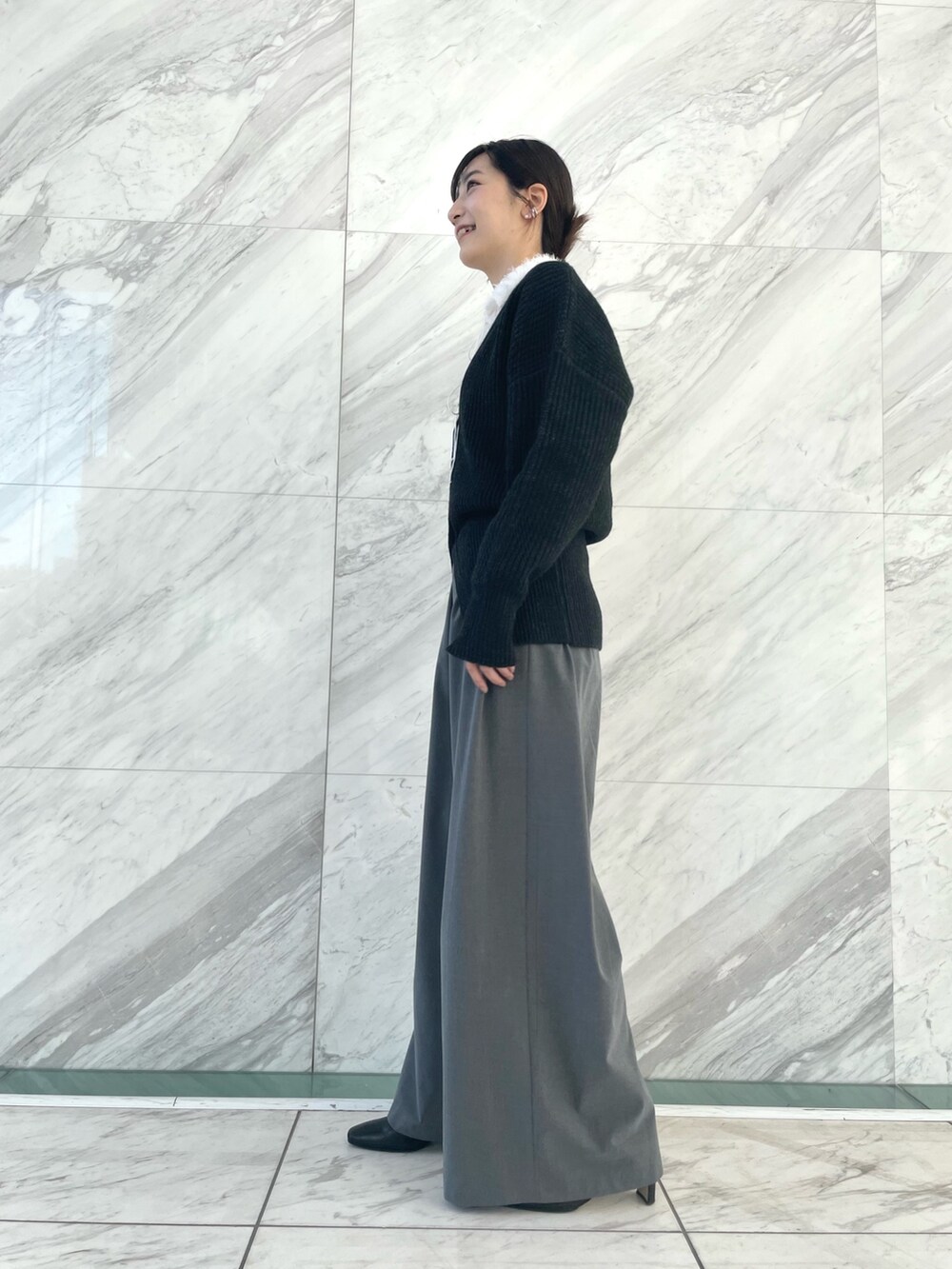 グレー系のカーディガン/ボレロ、ホワイト系のシャツ/ブラウス、グレー系のその他パンツを着用したレディースの冬コーディネートの2枚目の写真