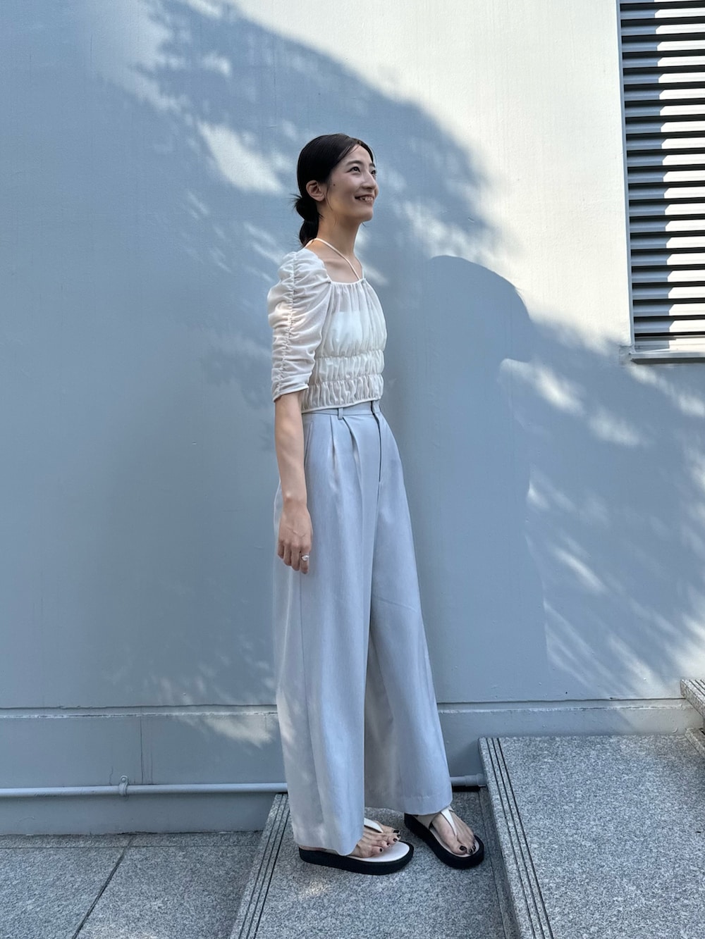 グレー系のその他パンツ、ホワイト系のシャツ/ブラウスを着用したレディースの夏コーディネートの3枚目の写真