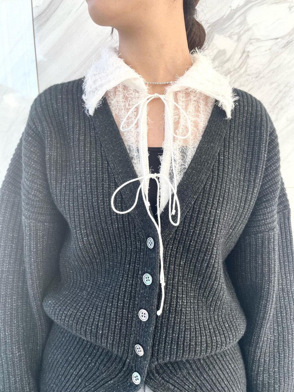 グレー系のカーディガン/ボレロ、ホワイト系のシャツ/ブラウス、グレー系のその他パンツを着用したレディースの冬コーディネートの4枚目の写真