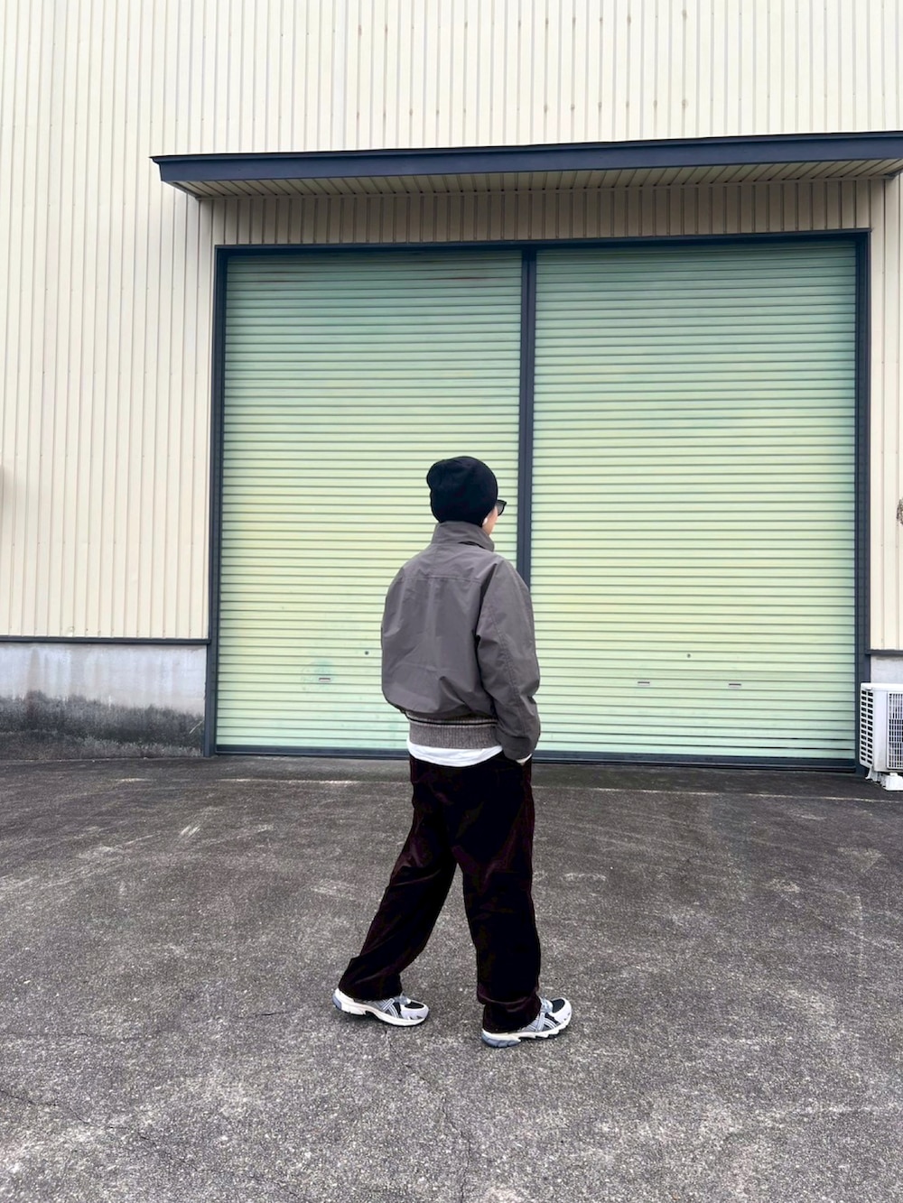 ブラック系のスニーカー、グリーン系のジャケット/アウター、ブラウン系のパンツを着用したレディースの冬コーディネートの2枚目の写真